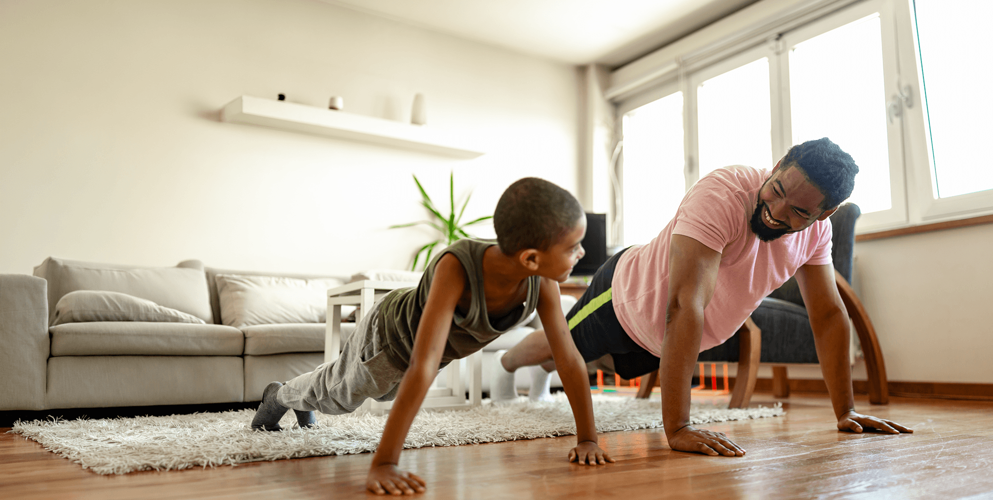 Man and Older son doing press-ups at home together